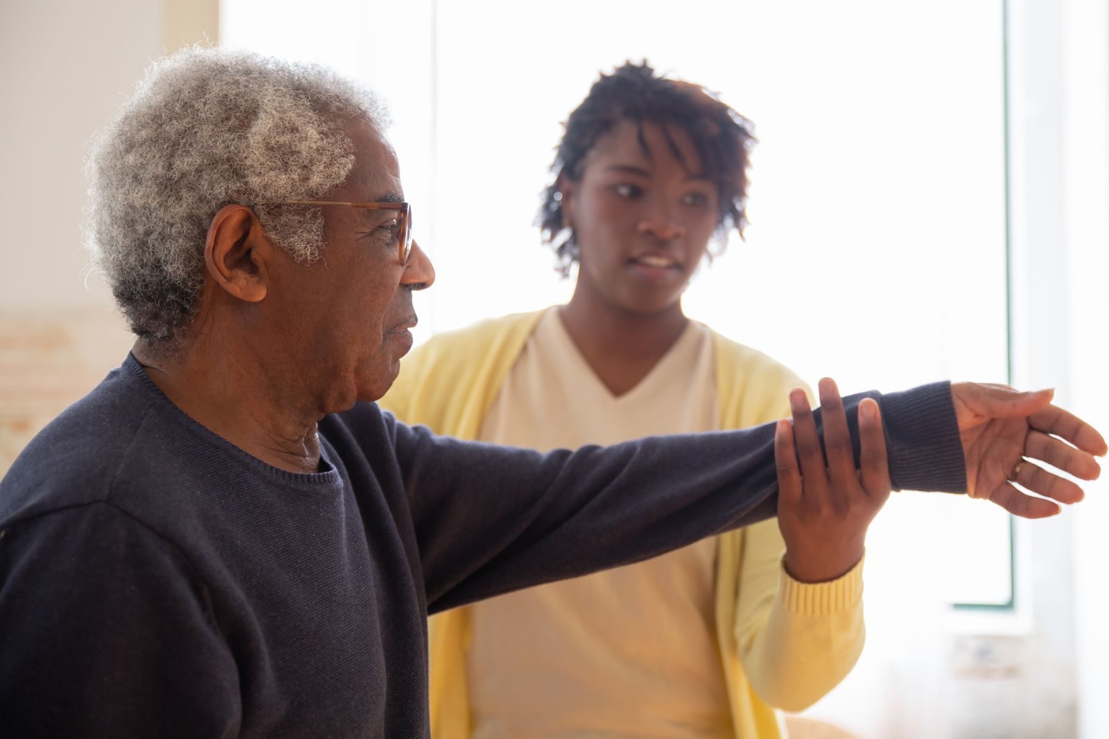 REACH Home Care caregiver helping a client with Parkinson's walk safely at home in the Tri-Cities