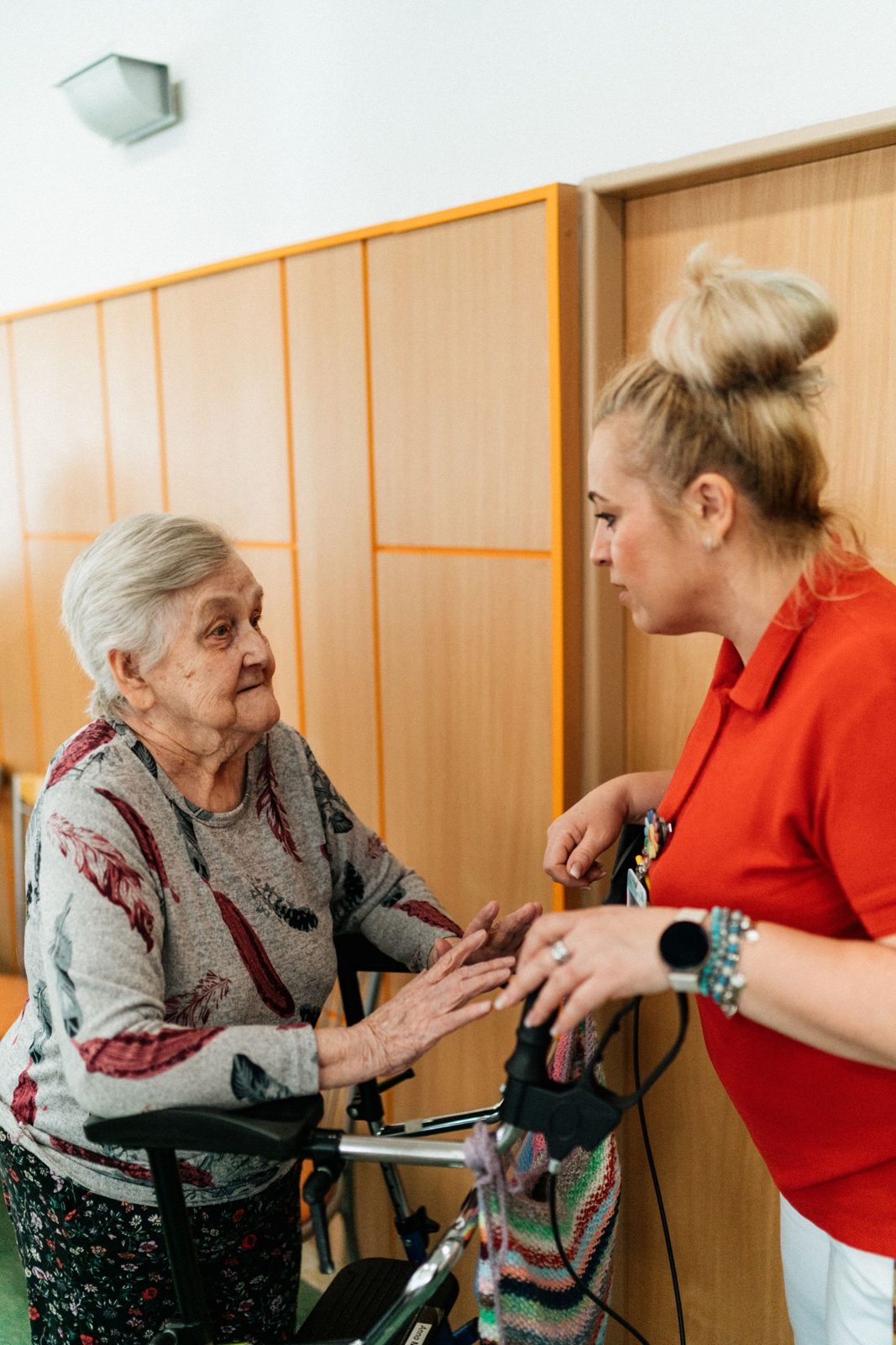 REACH Home Care caregiver sitting with an elderly resident in an assisted living apartment