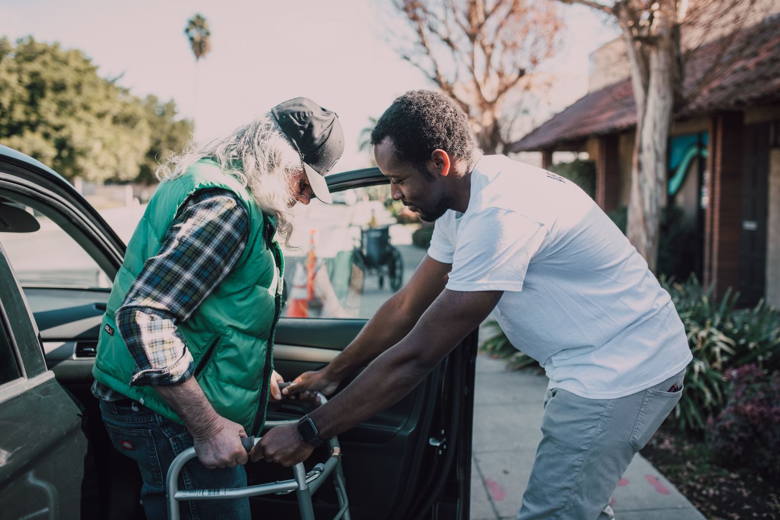 REACH Home Care caregiver helping a senior client out of a car at a medical appointment