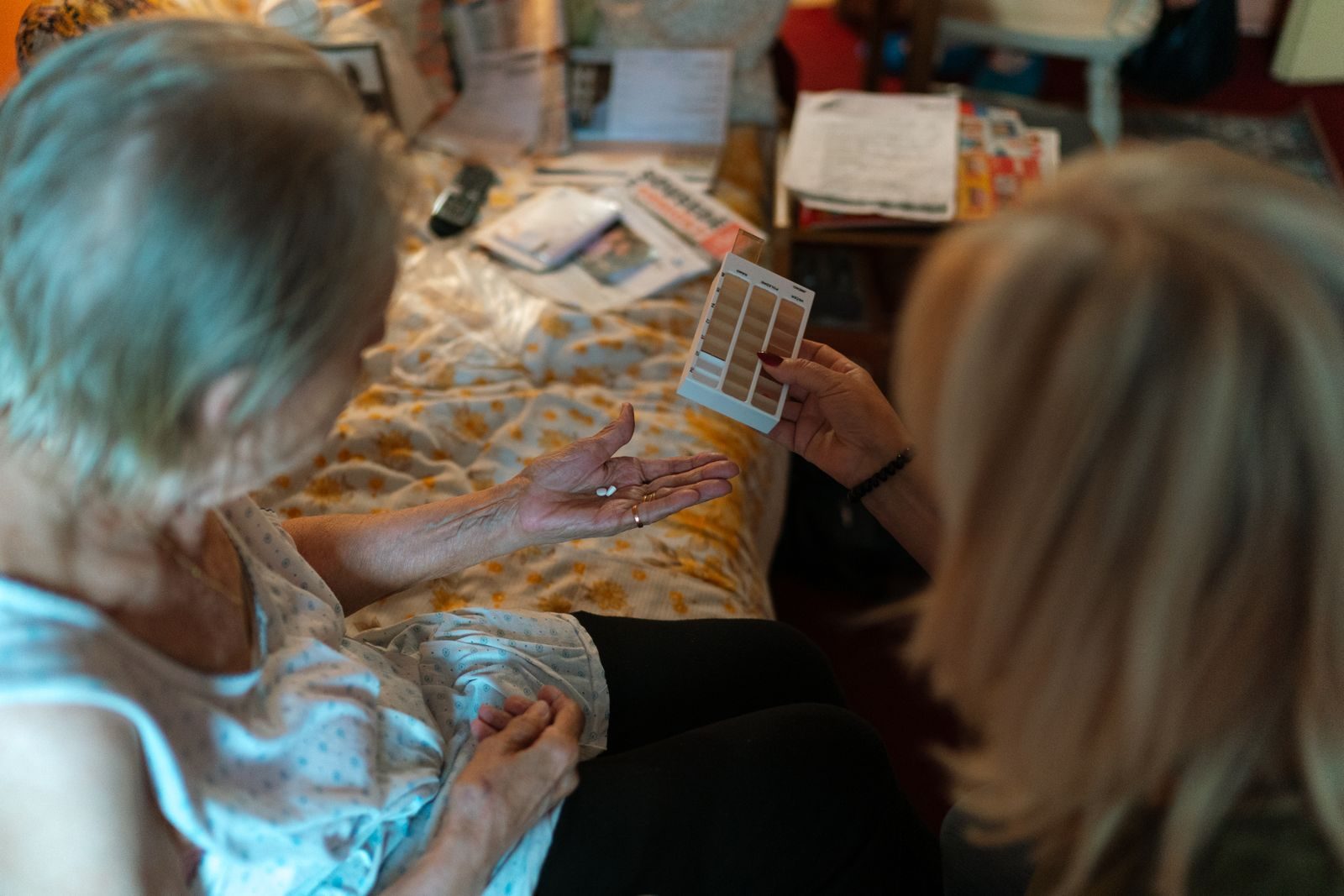 Close-up view of a caregiver assisting an elderly person with medication